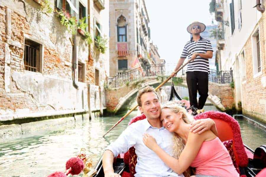 Romantic travel couple in Venice on Gondole ride romance in boat 