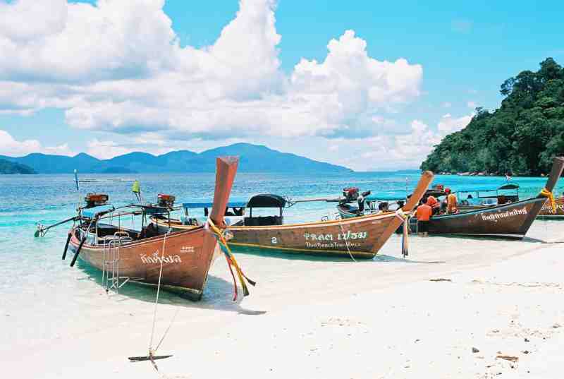 boats on a beach in thailand