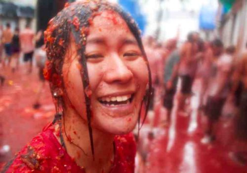 Bunol, Spain - August 28: The girl in crushed tomatoes laughs on Tomatina festival in Bunol, August 28, 2013 in Spain